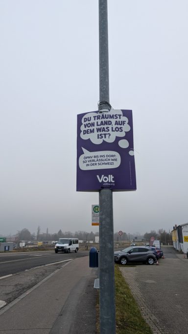 Lila Plakat mit der Aufschrift "DU TRÄUMST VON LAND, AUF DEM WAS LOS IST?